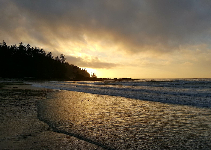 Waves on a sandy beach at dusk.