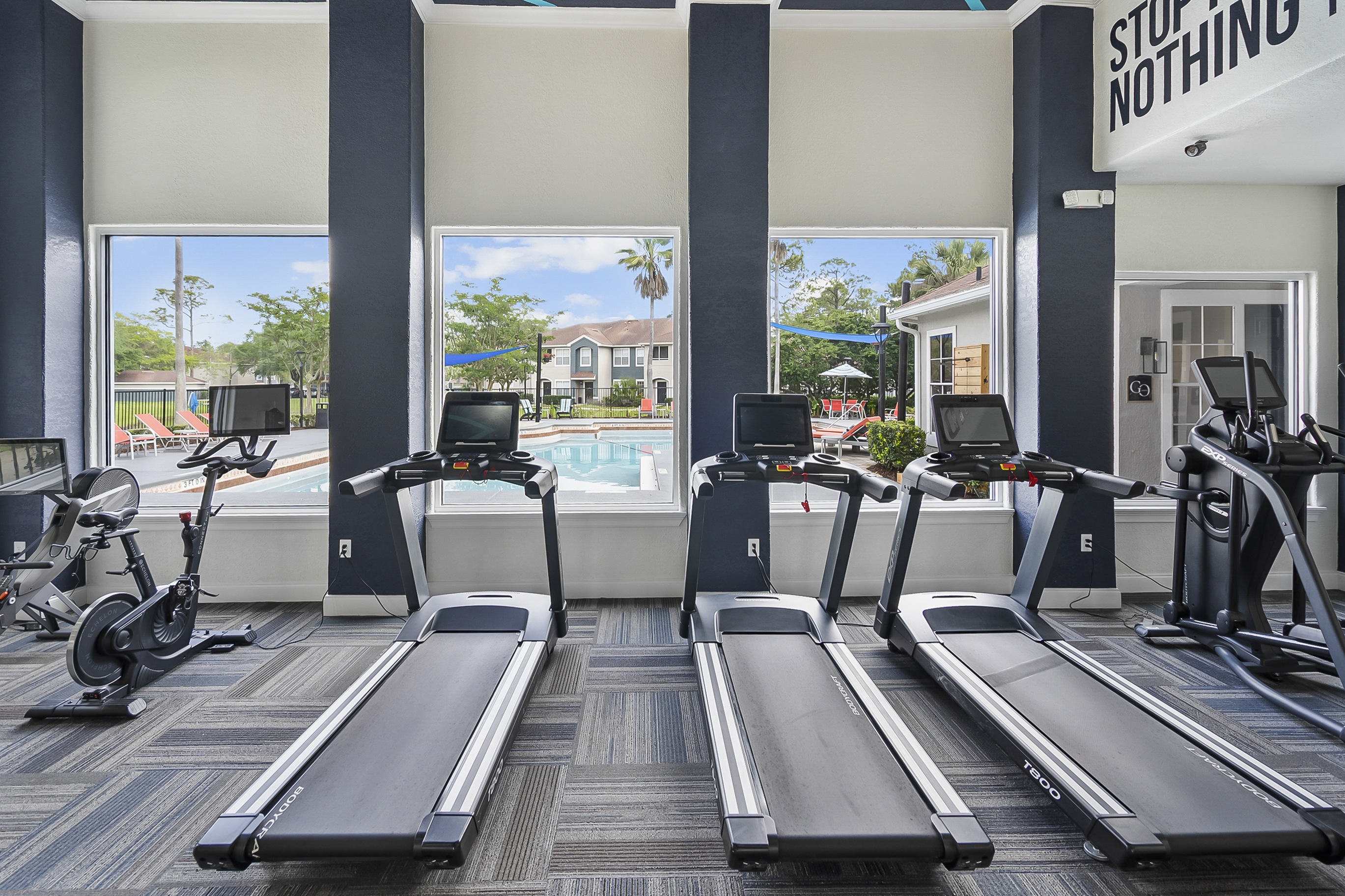 A gym with treadmills and elliptical machines.