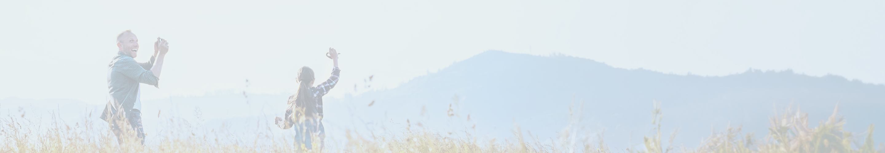 A man taking a photo of a woman in a field.