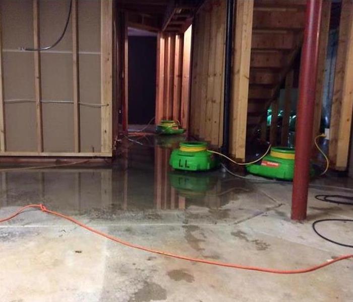 Storm damage occurred at this Silver Lake home when a powerful thunderstorm dumped inches of water onto this unfinished home site. The lower portion of the home, including the garage shown here, had a layer of standing water on it. The water was easily cleaned up with truck mounted extractors. The concrete slab had absorbed a lot of moisture and need to be dried using air movers and dehumidifiers.