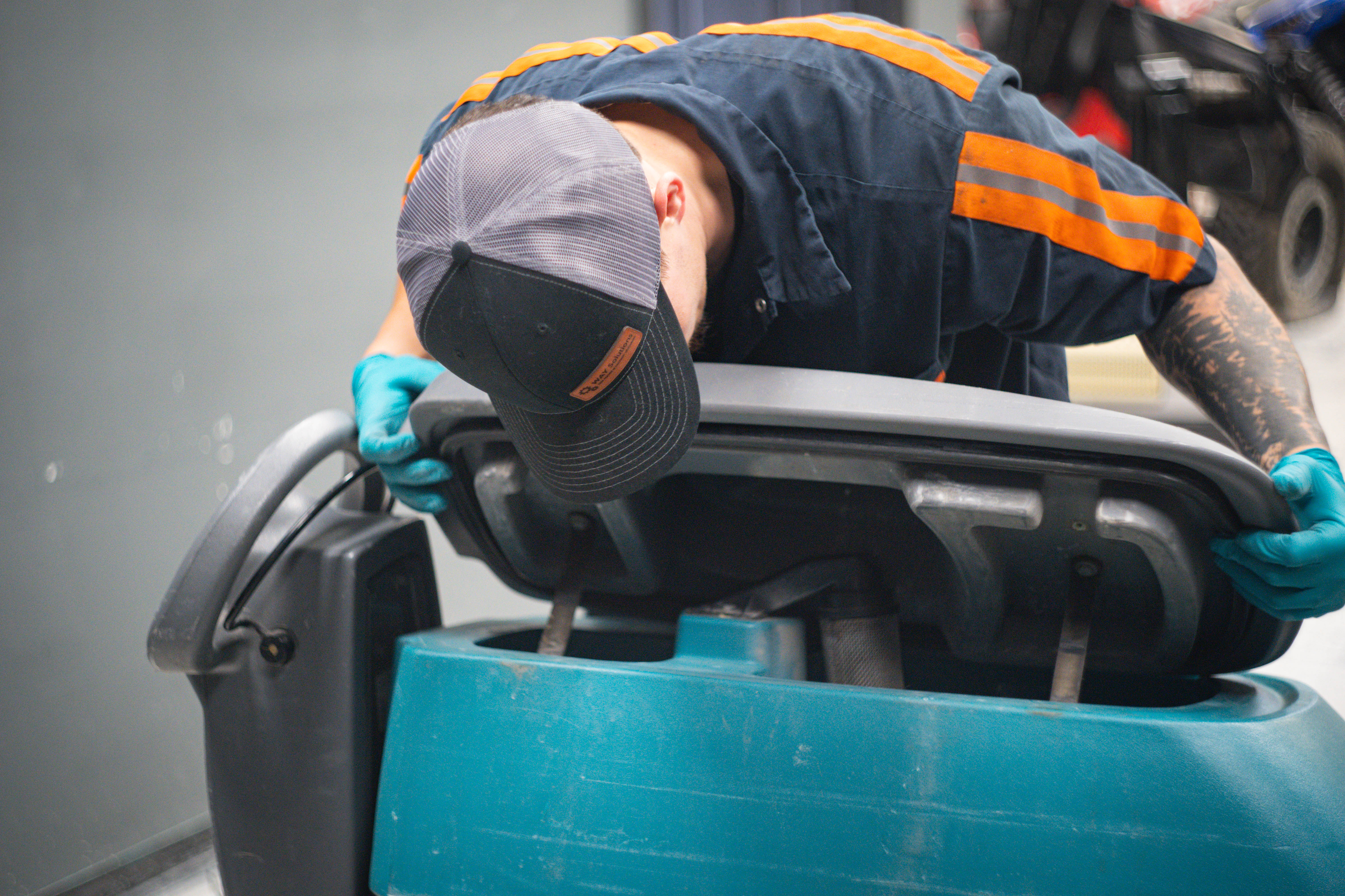 A WaySolutions field technician performs a hands-on mechanical overhaul on the core base of a Minuteman E20 walk-behind floor scrubber. Whether you need an expert on-site repair in Layton, Utah, or simply need to order genuine replacement motors, brushes, or squeegees, we are your complete equipment partner.