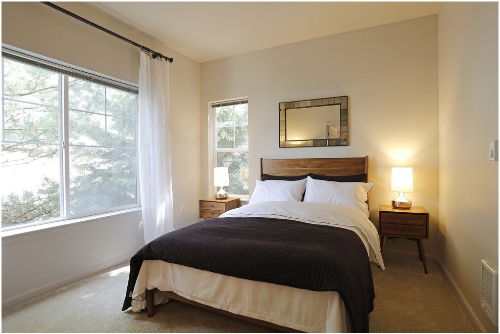 A bedroom with a large bed and a window with curtains