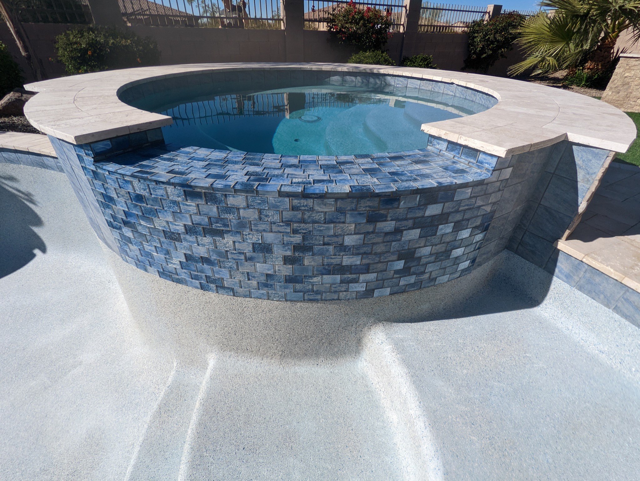 Tile can completely change the appearance of a pool and spa. This remodel uses a mix of blue and neu 