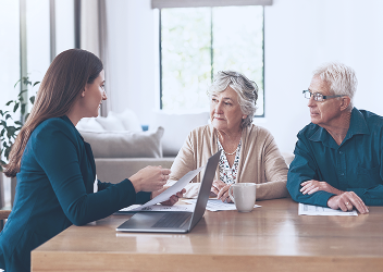 A couple meeting with an advisor at a table.