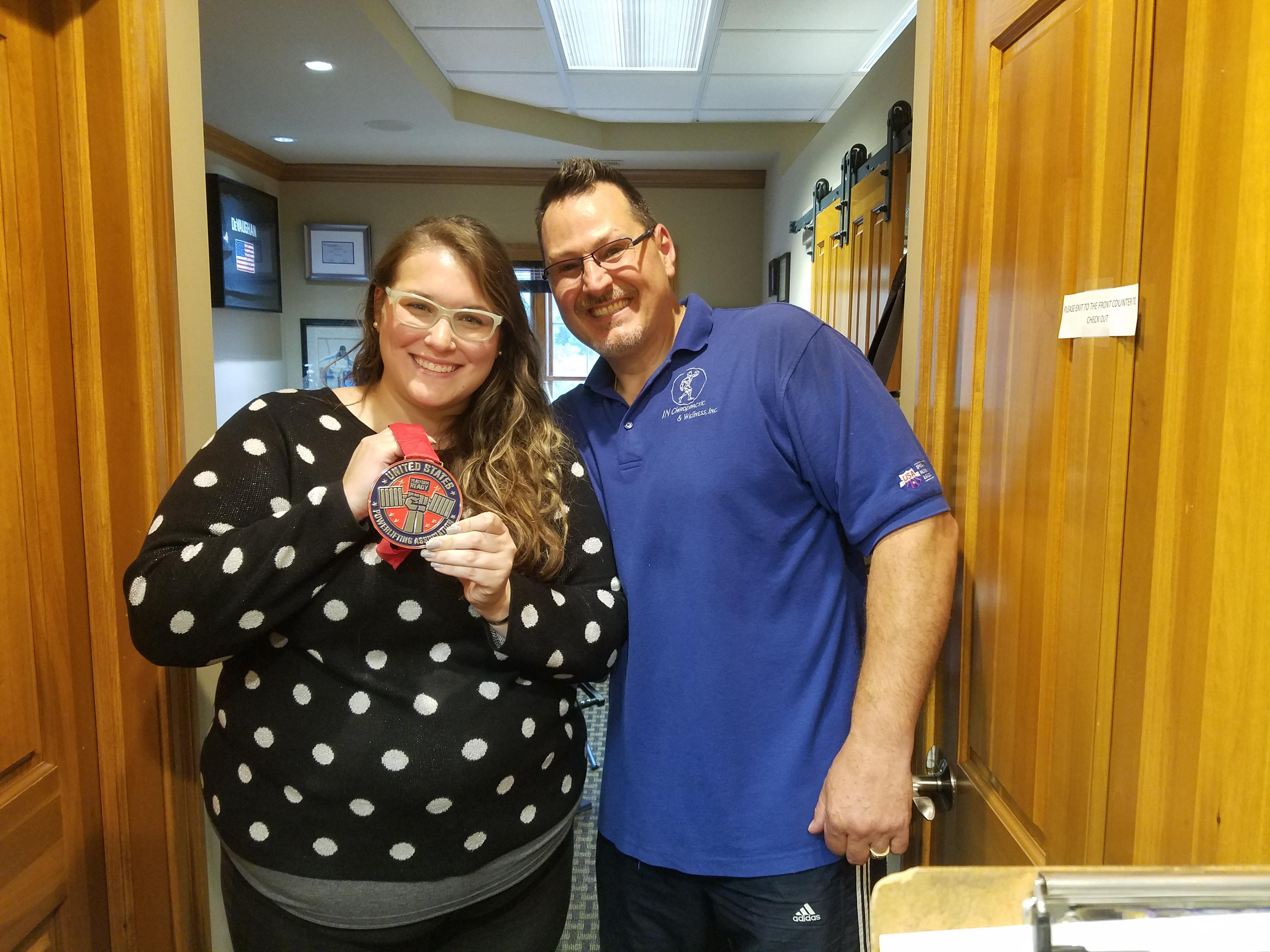 Anastasia Wallace with one of her winning metals from USPA powerlifting.