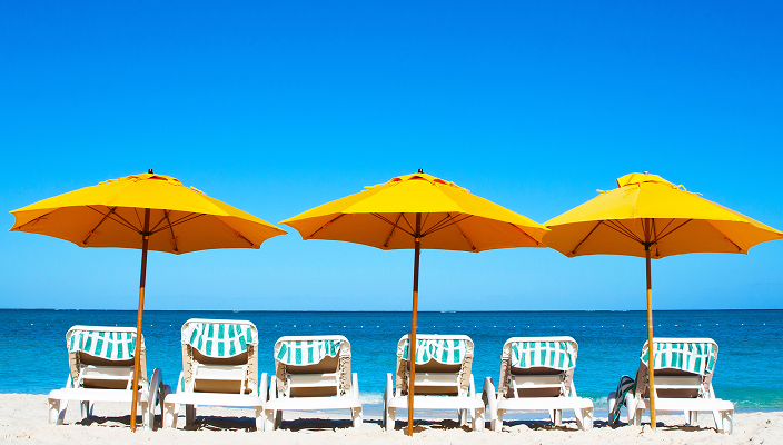 Beach chairs and umbrellas in the sand.