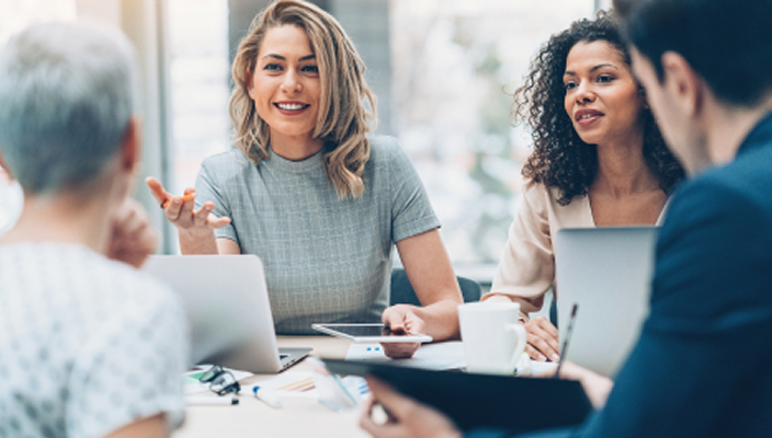 Professionals collaborating with each other around a boardroom table.