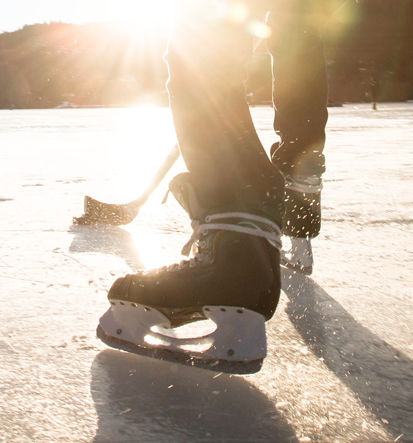A hockey player playing shinny on a frozen lake.