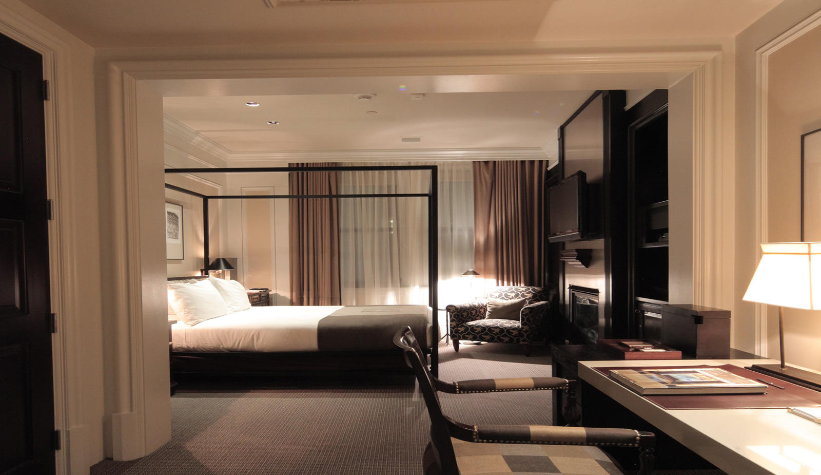 XV Beacon, a luxury Hotel in Boston. View of a spacious hotel room with ambient lighting and large windows.
