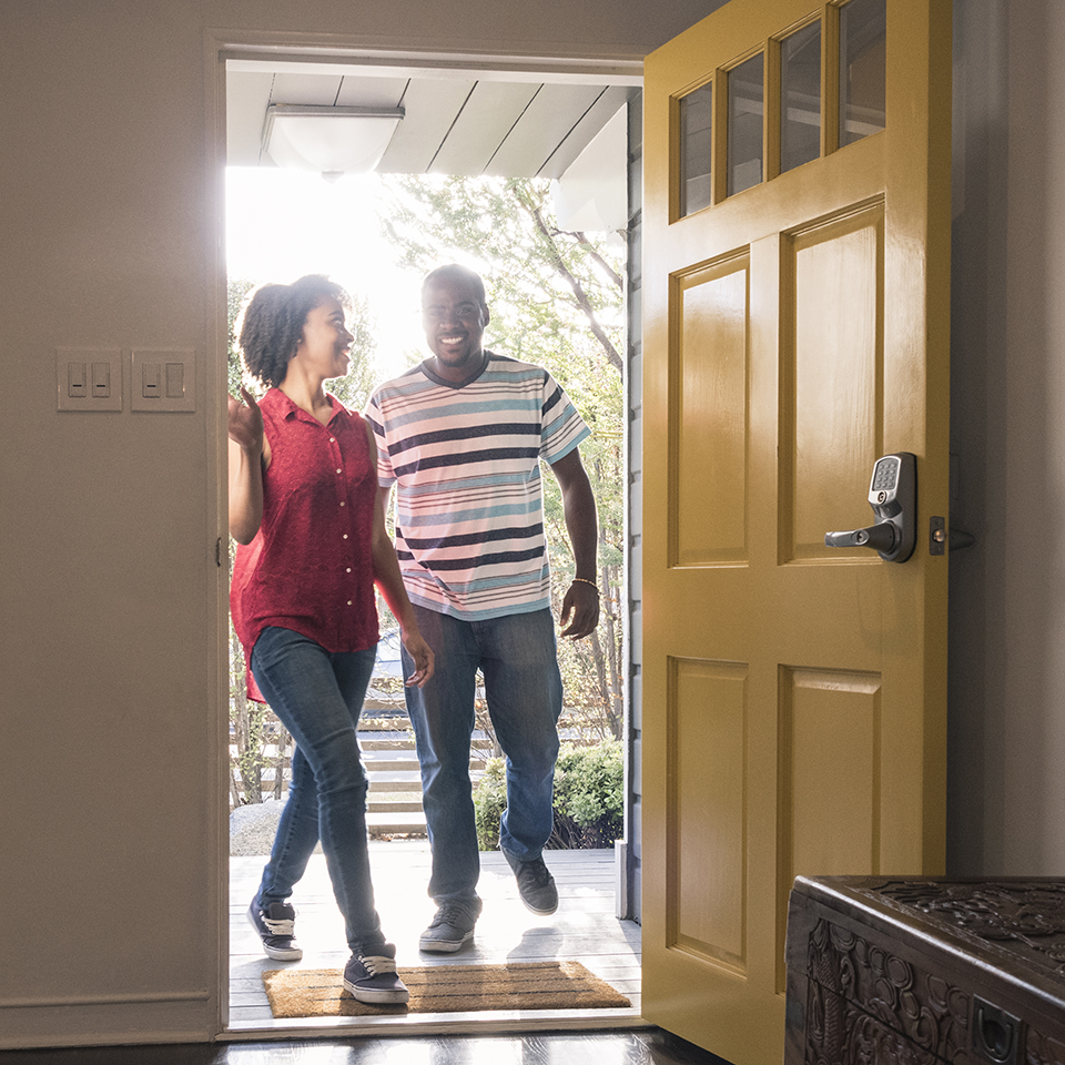 A man and woman walking into a house