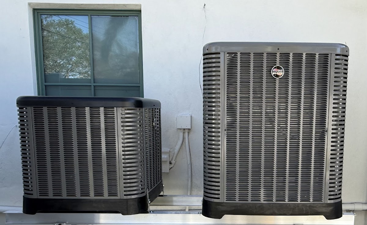 Two outdoor air conditioning condenser units installed side by side for efficient cooling performance.