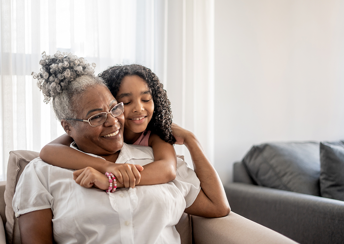 A granddaughter hugging her grandmother.