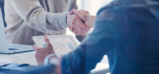 Close up of an advisor and client shaking hands.