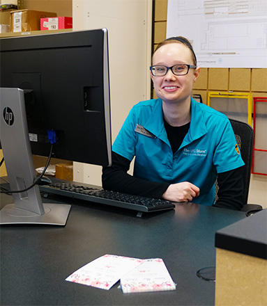 The UPS Store associate sitting in front of printed wedding materials