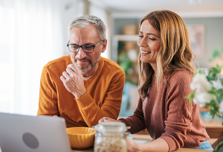 A couple reviewing their financial plan on their laptop.