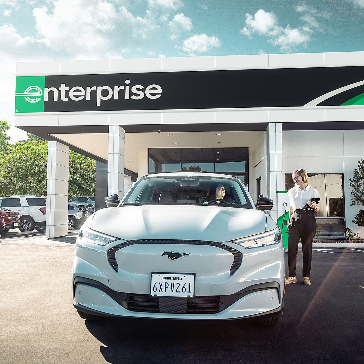 Enterprise Rent-A-Car à Saint-Hilaire: Enterprise employee helping customer with electric car rental