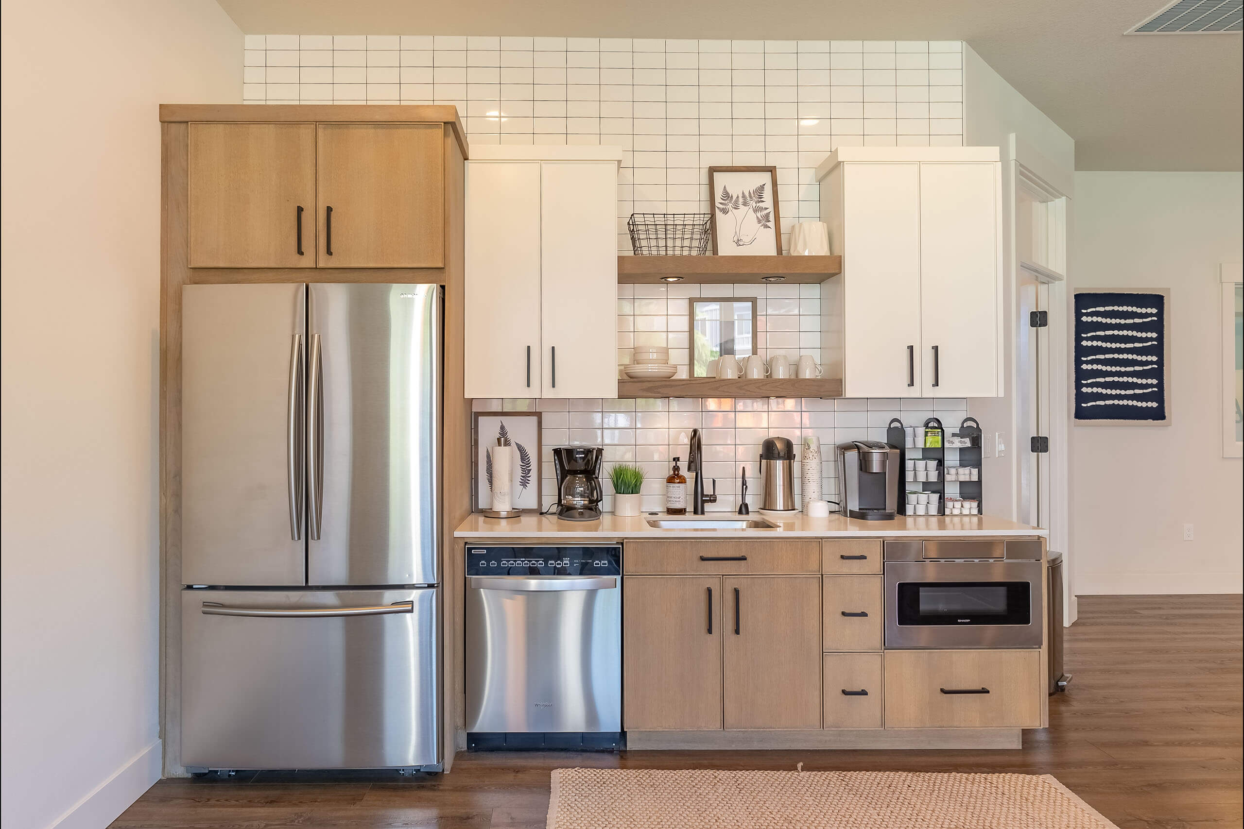 A kitchen with a refrigerator, cabinets, and a tiled backsplash.