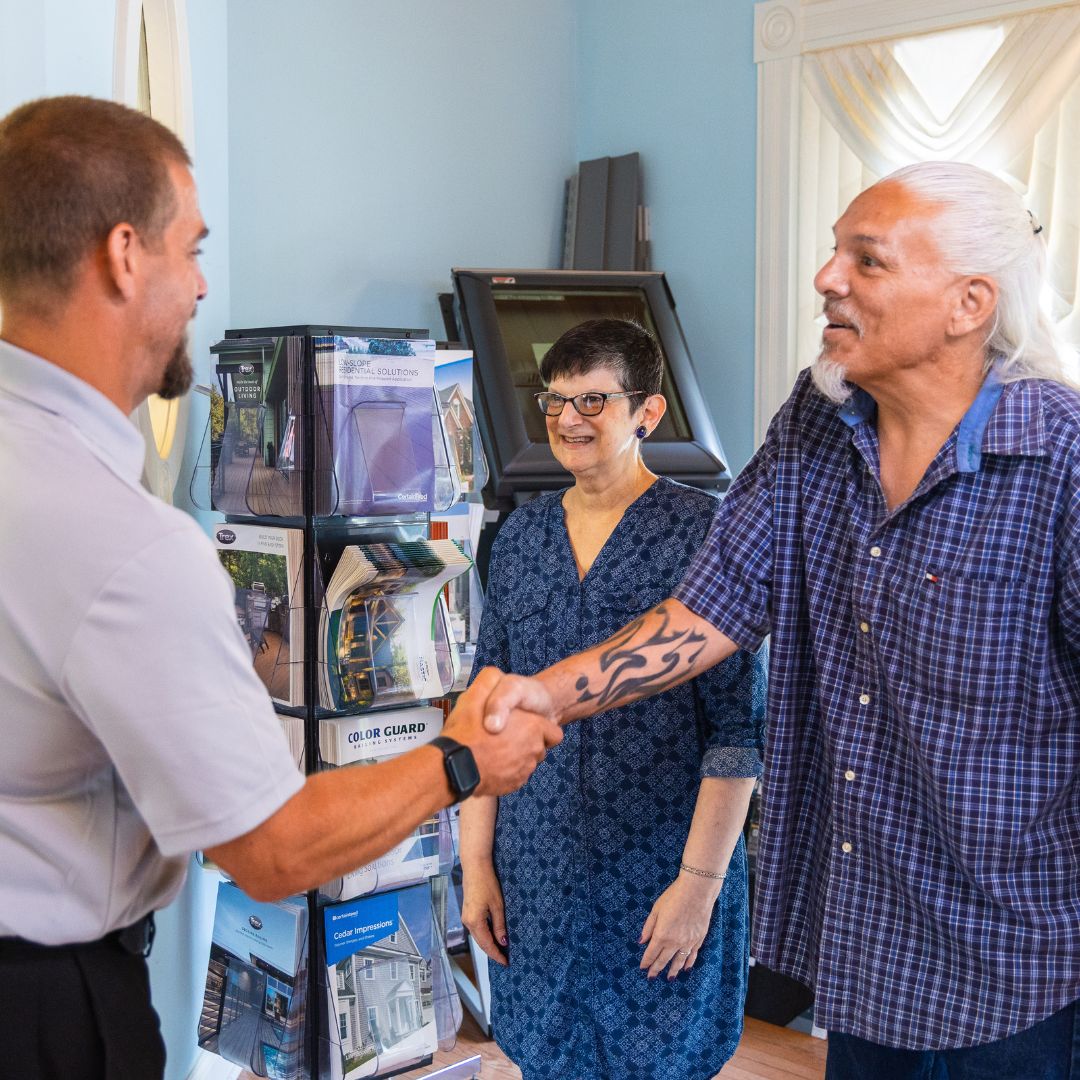 A Fiderio team member warmly welcomes clients into the showroom with a friendly handshake.