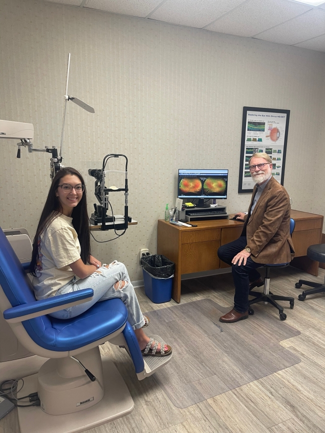 Dr. Chism sitting with patient. 