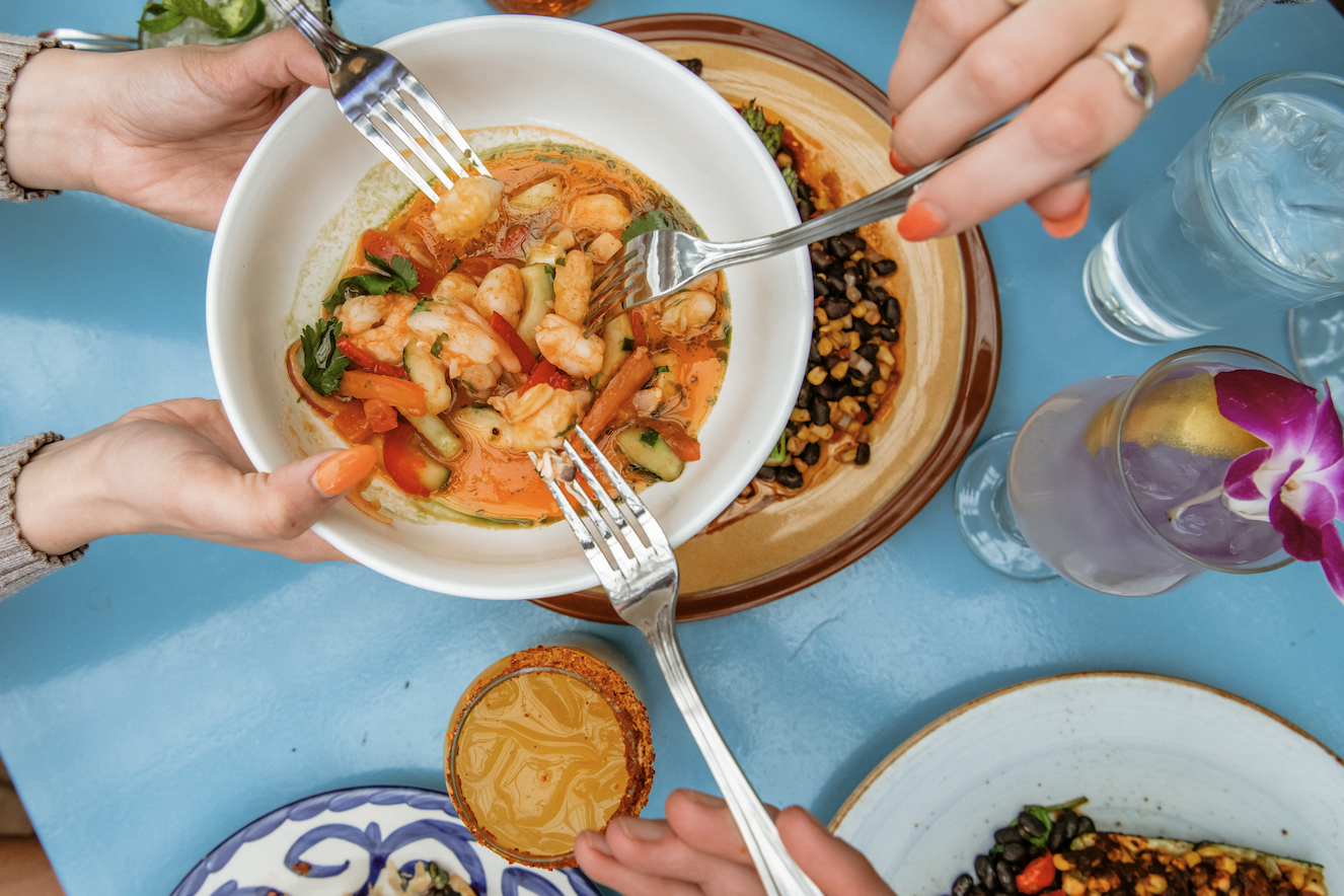 People passing a plate of ceviche