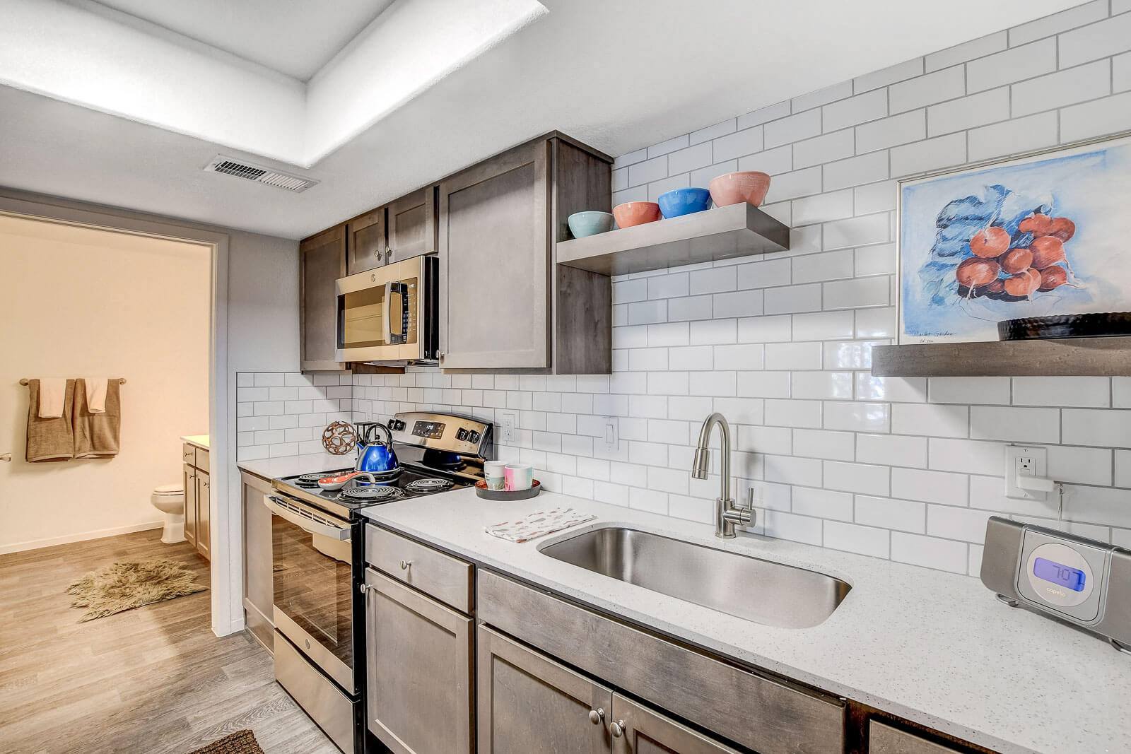 A modern kitchen with stainless steel appliances and a white tiled backsplash