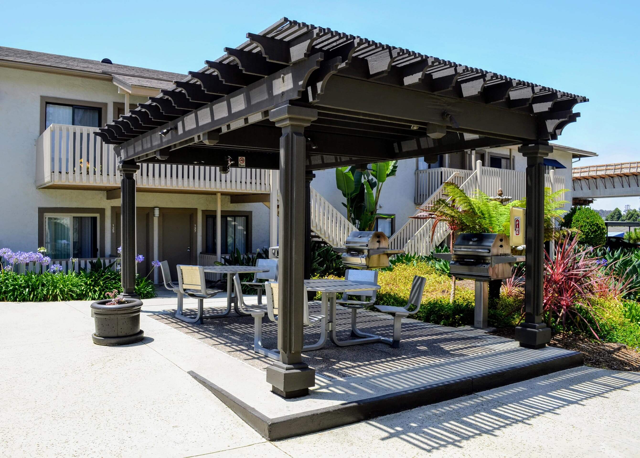 A patio with a table and chairs under a pergola.