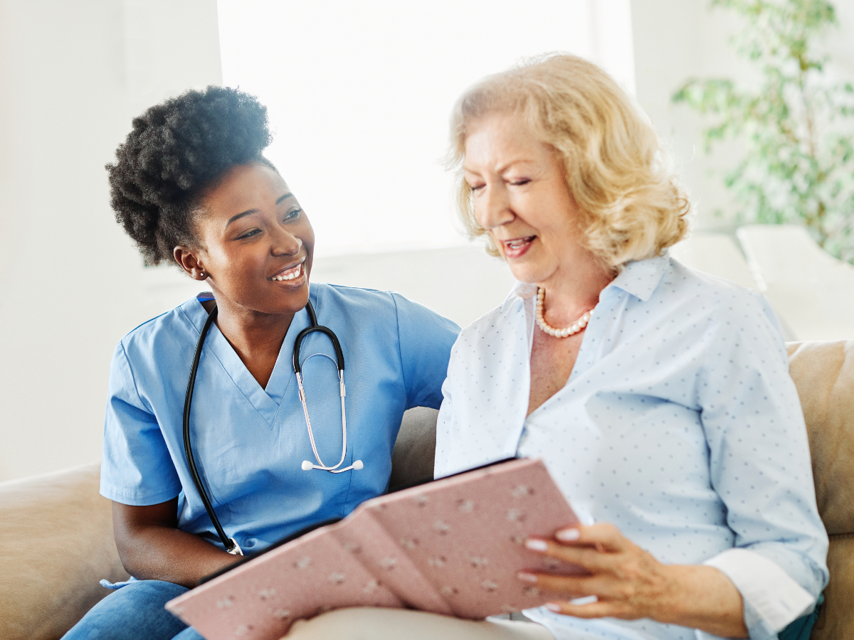 Caregiver reviewing care information with a senior client during an in-home care visit.