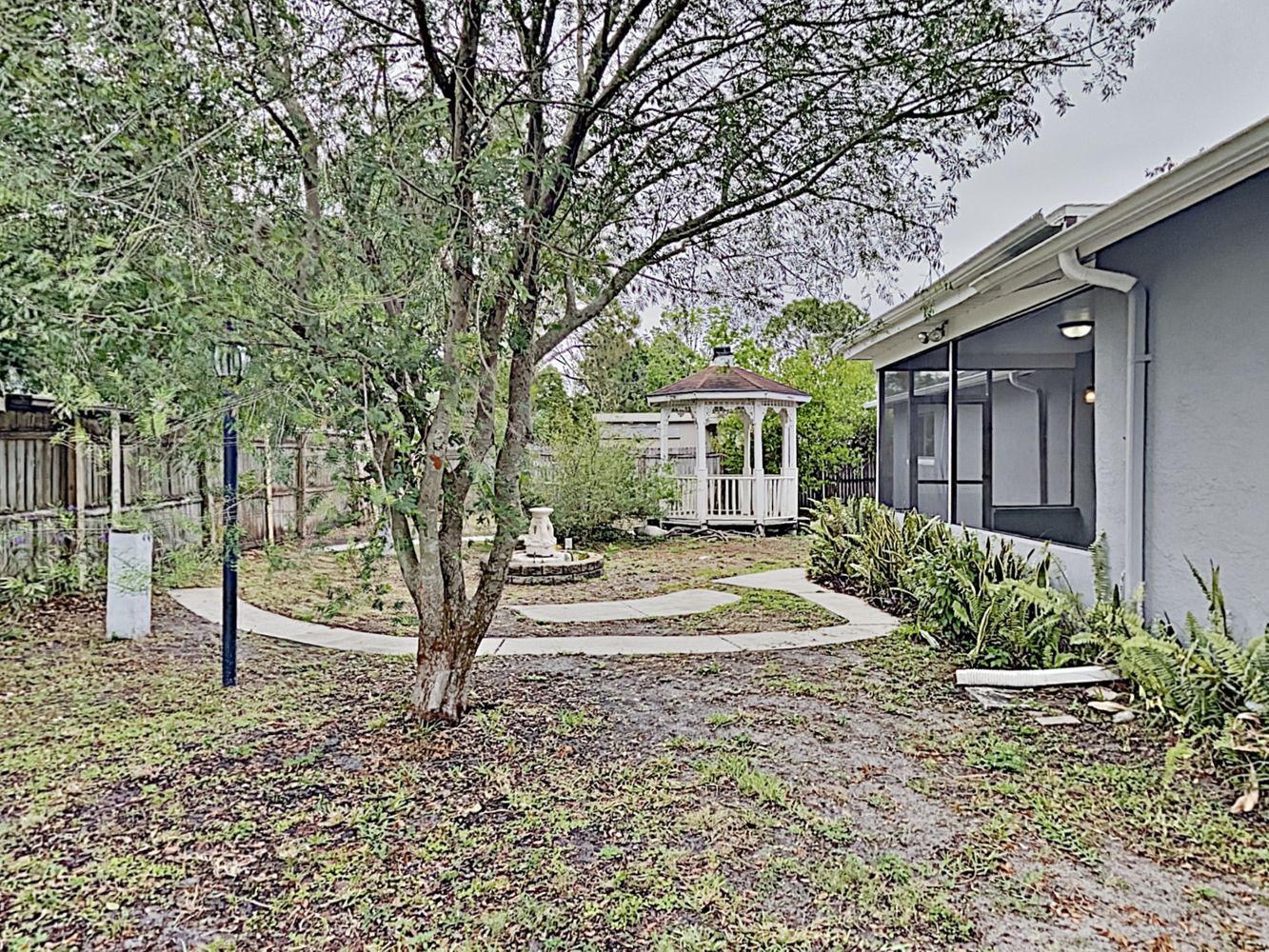 Backyard showing porch with screen and gazebo at Invitation Homes Tampa.