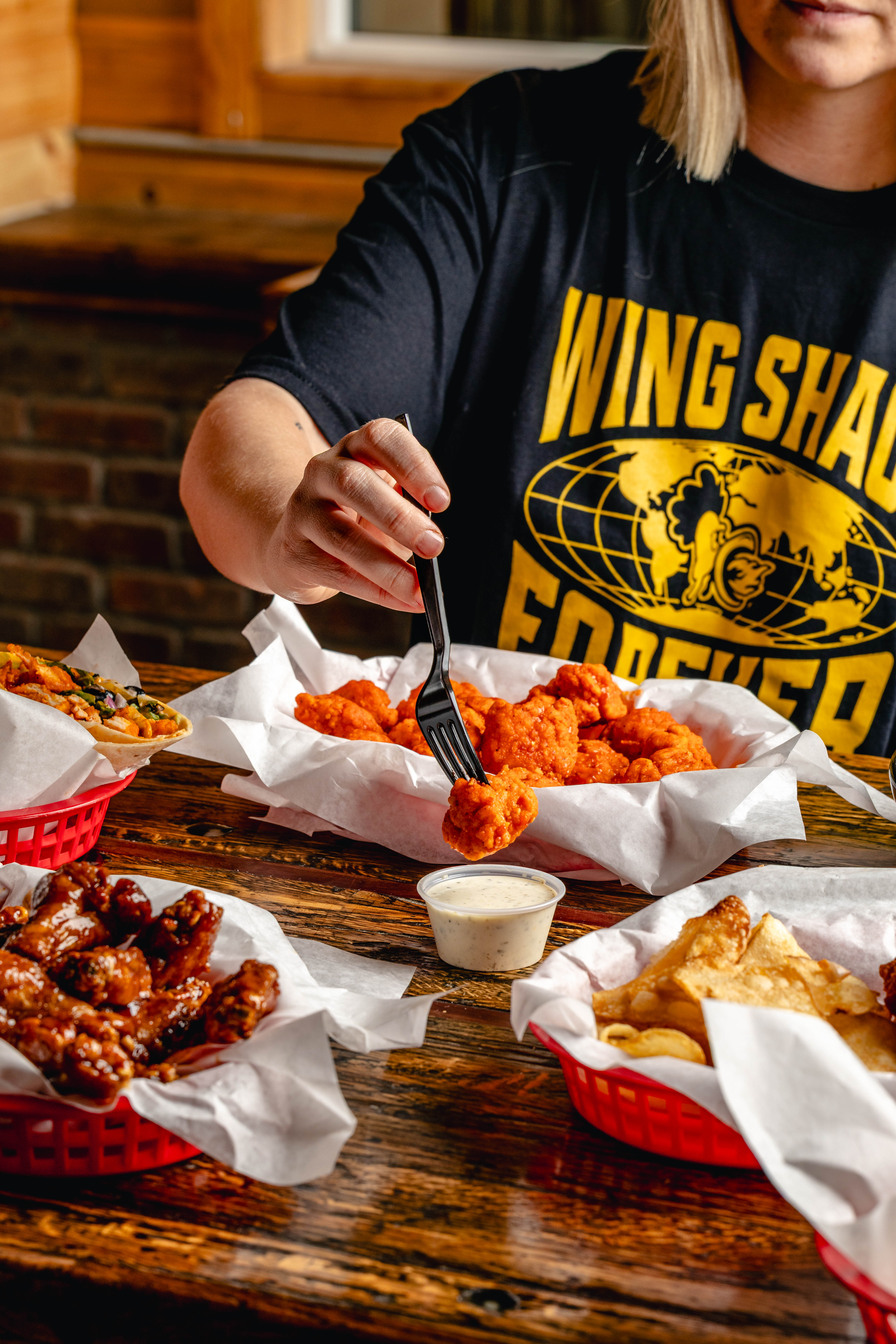 Garlic Hot Boneless Wings Being Dipped in Ranch