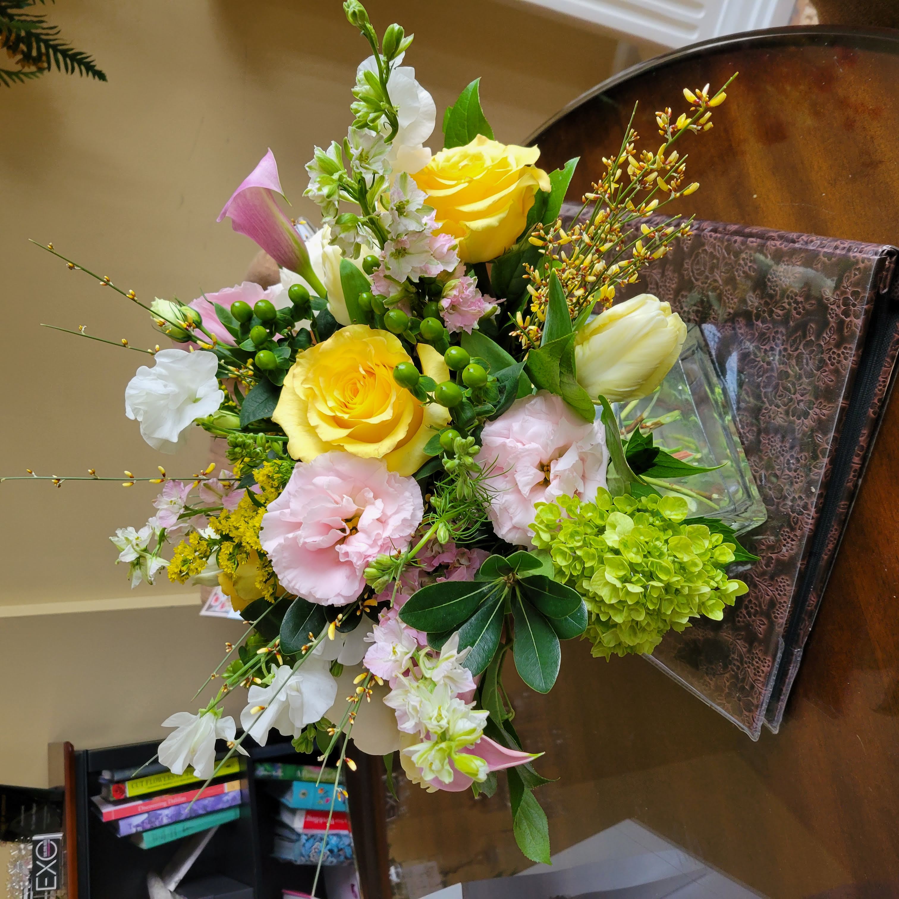 Spring arrangement in square vase with tulips, peonies, sweet peas, and mini calla lilies.