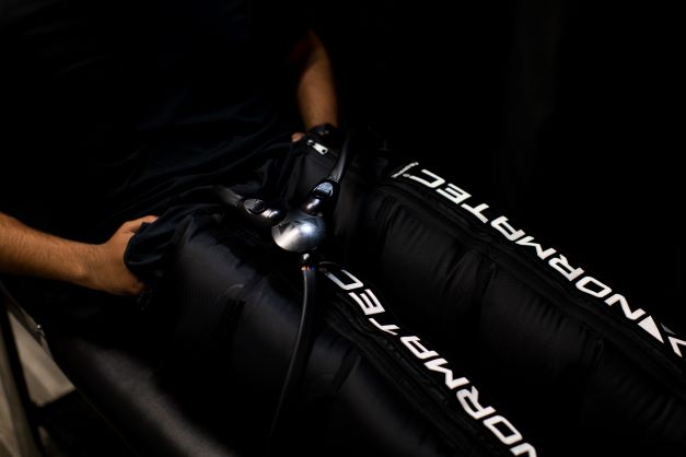 NormaTec Compression Therapy is a treatment modality that uses pulse massage patterns to boost recovery. The dynamic compression device uses compressed air to massage limbs, mobilize fluid, and fight inflammation. Limbs are inserted into sleeves that are inflated to compress the muscles. The compression system then pulses up the limbs, squeezing pain-causing fluid & lactic acid out of them. The limbs are then replenished with fresh blood, stimulating recovery.
