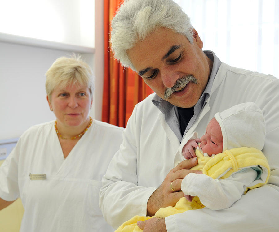 Chefarzt Dr. Olaf Neumann mit Baby