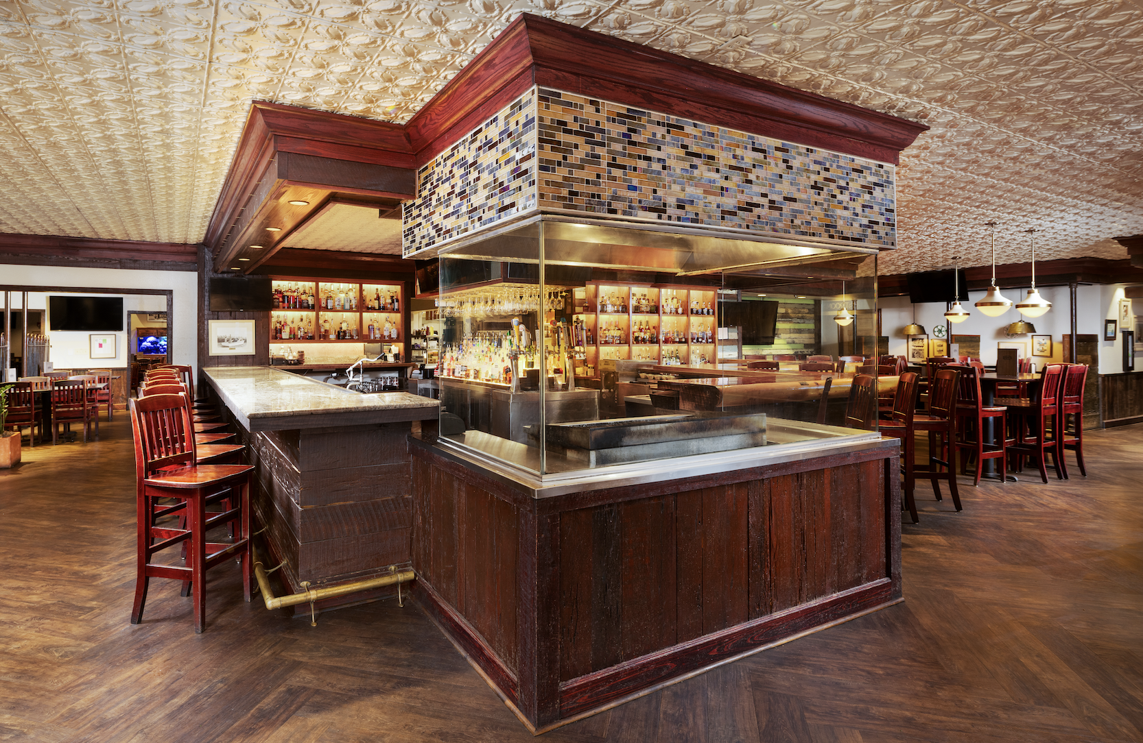 Lafayette's bar centerpiece pairs a colorful mosaic tile hood with a vintage pressed-tin ceiling, wr 