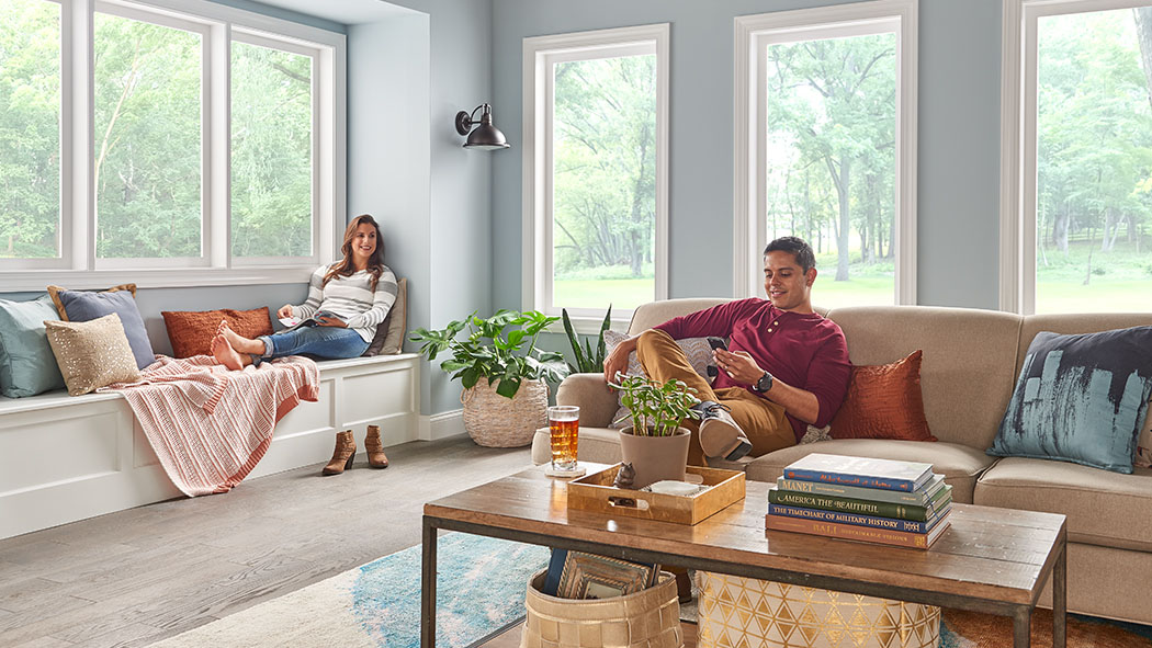 A couple sitting in a living room booking an appointment online with a Carrier dealer