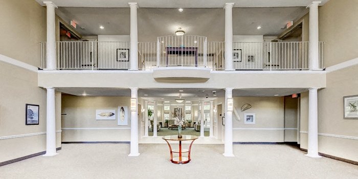 the lobby of a large building with a balcony and a table