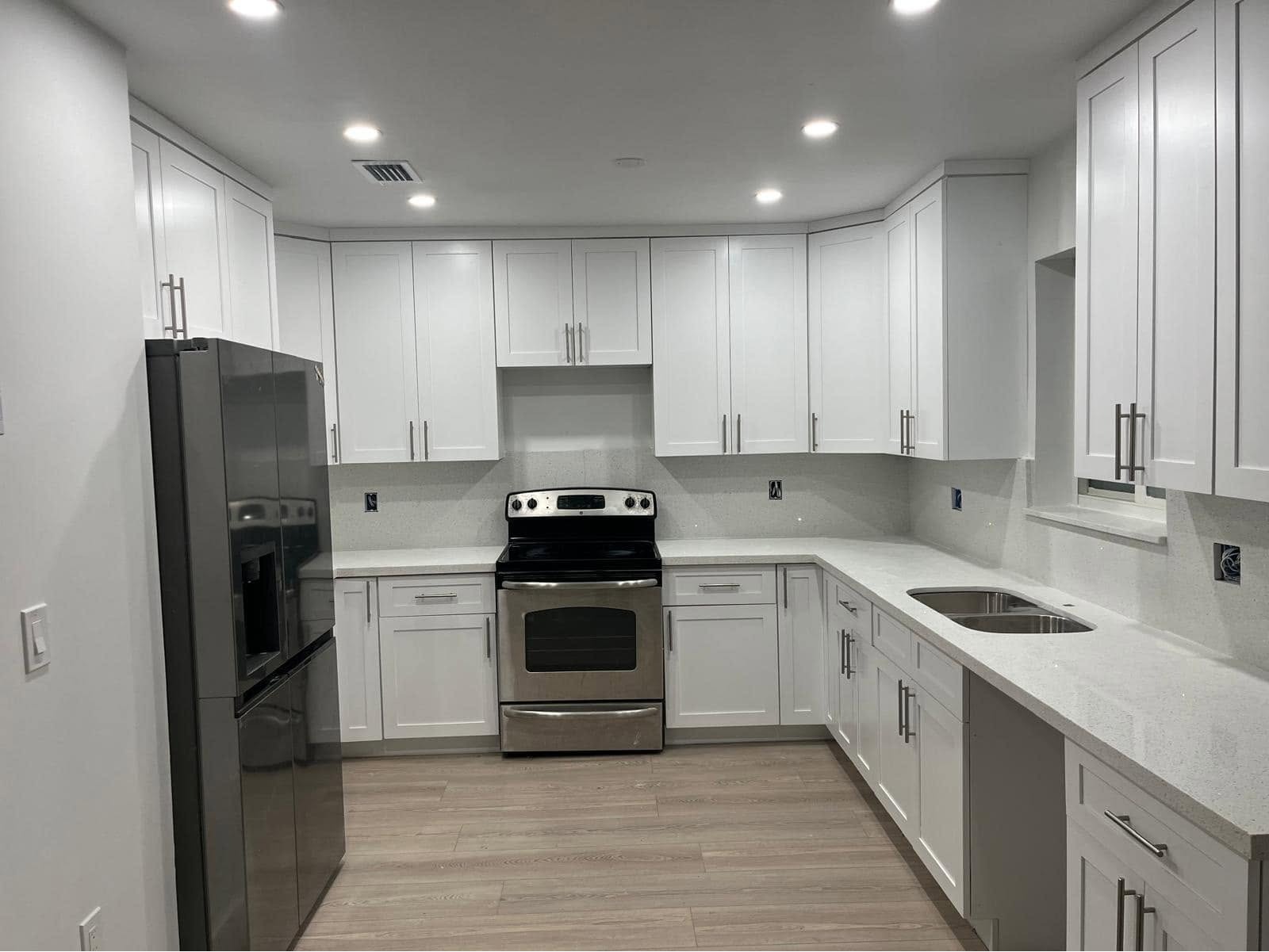 Remodelación de cocina funcional en U con gabinetes blancos estilo shaker, encimeras de cuarzo blanc 