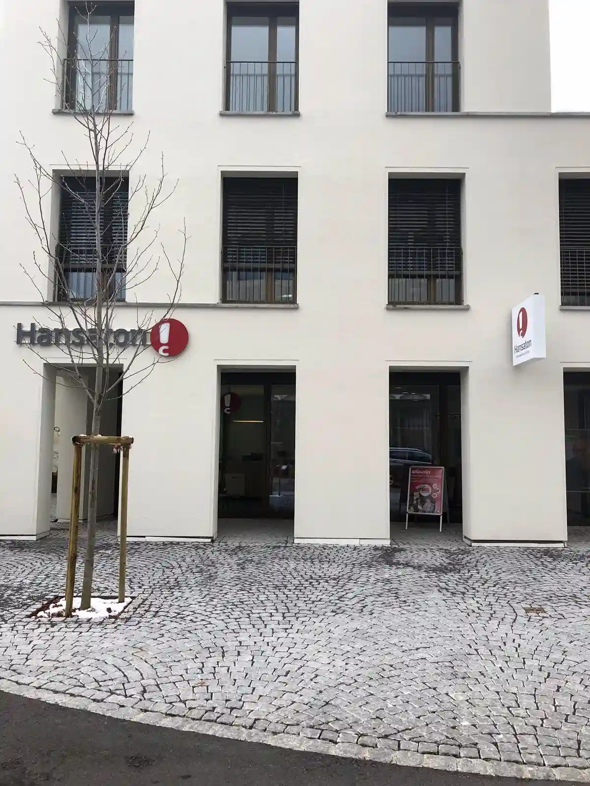 Hansaton Hörkompetenz-Zentrum Raiffeisenstraße 1a, Lustenau von der gegenüberliegenden Straßenseite kommend
