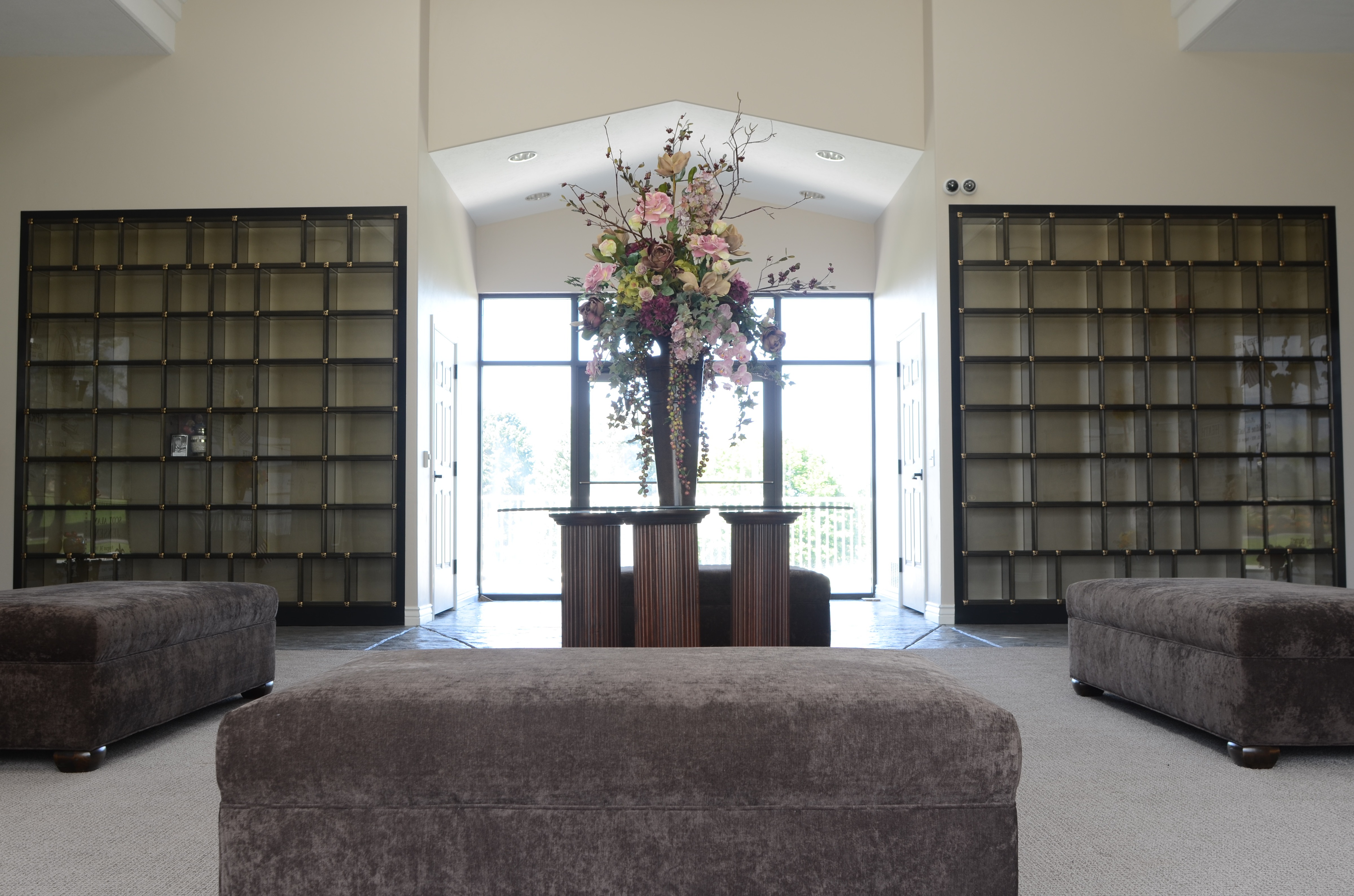A cremation niche room at Larkin Sunset Gardens in Sandy, lined with glass-front niches and opening onto the cemetery gardens.
