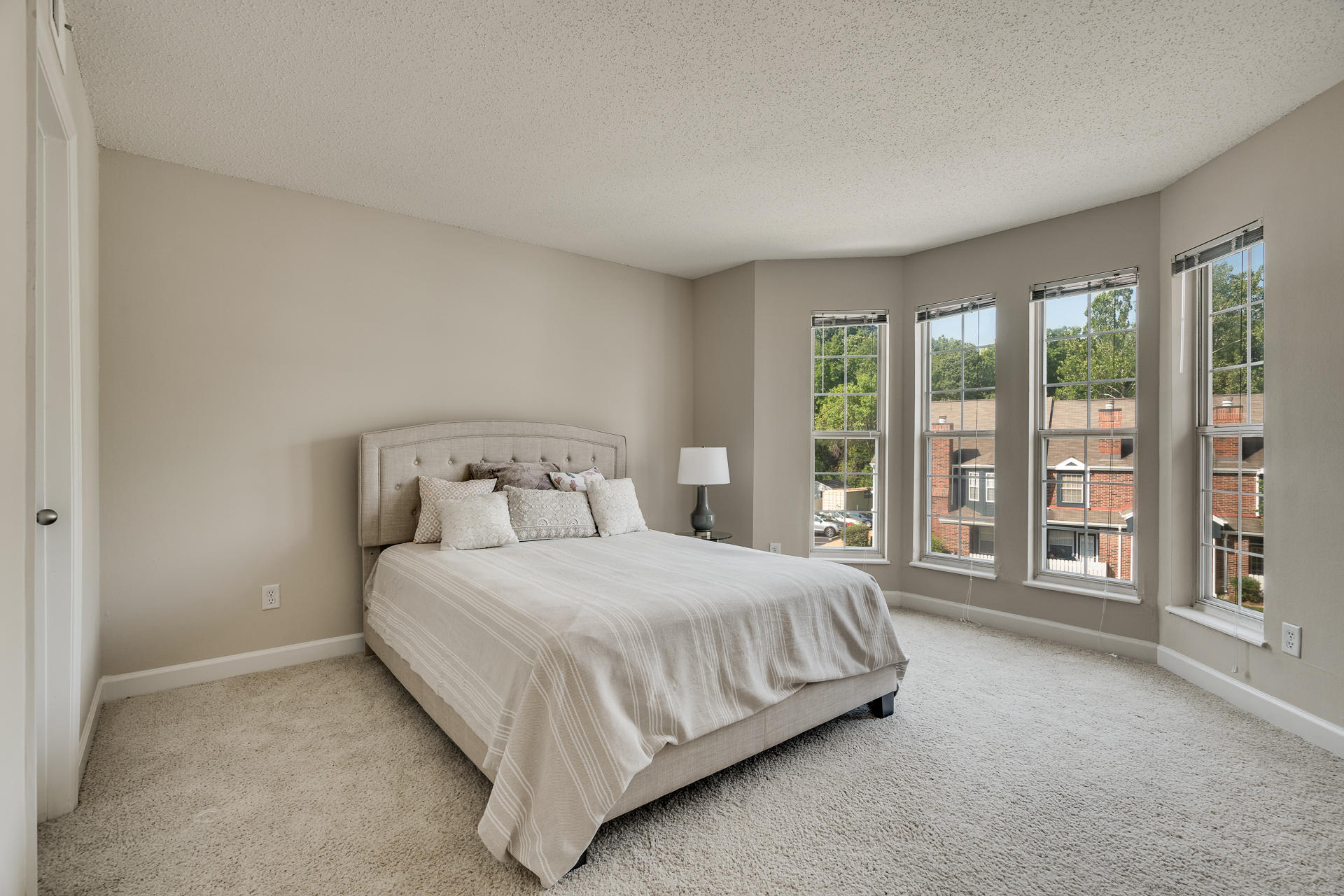 Carpeted Bedroom With Bay Windows