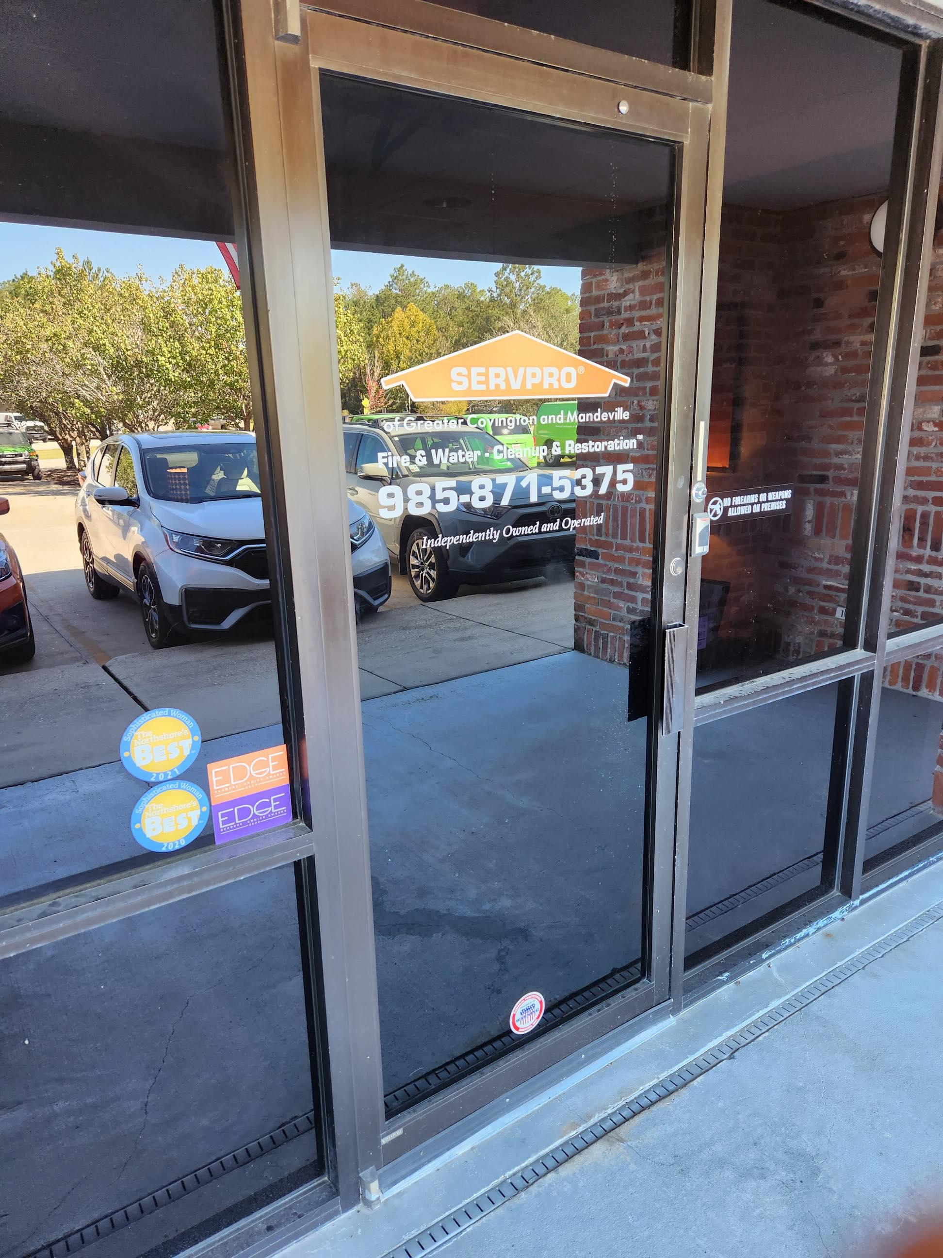 SERVPRO of Greater Covington and Mandeville's front office door with stickers of local awards for the best emergency restoration company.
