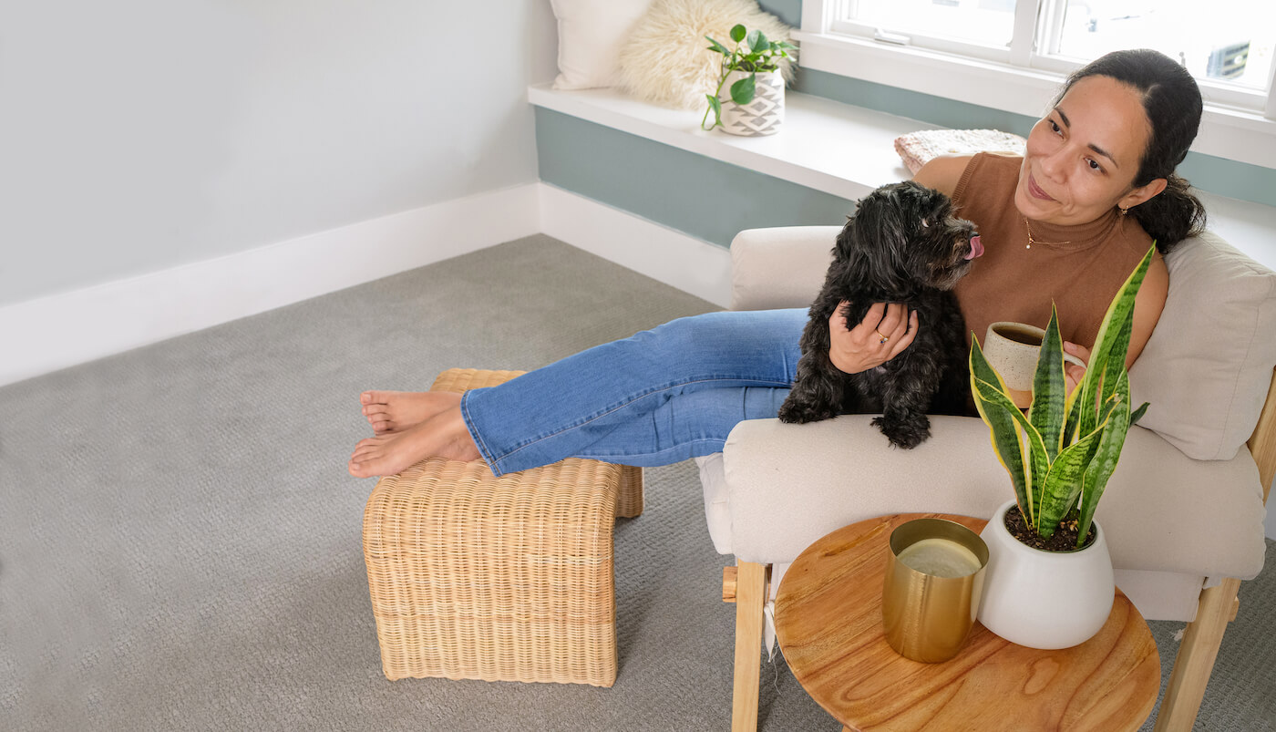 woman sitting on upholstered furniture holding a dog