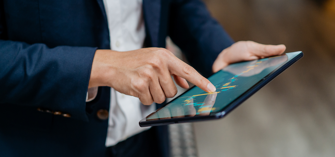 Close-up of an investment advisor looking at charts on a tablet.