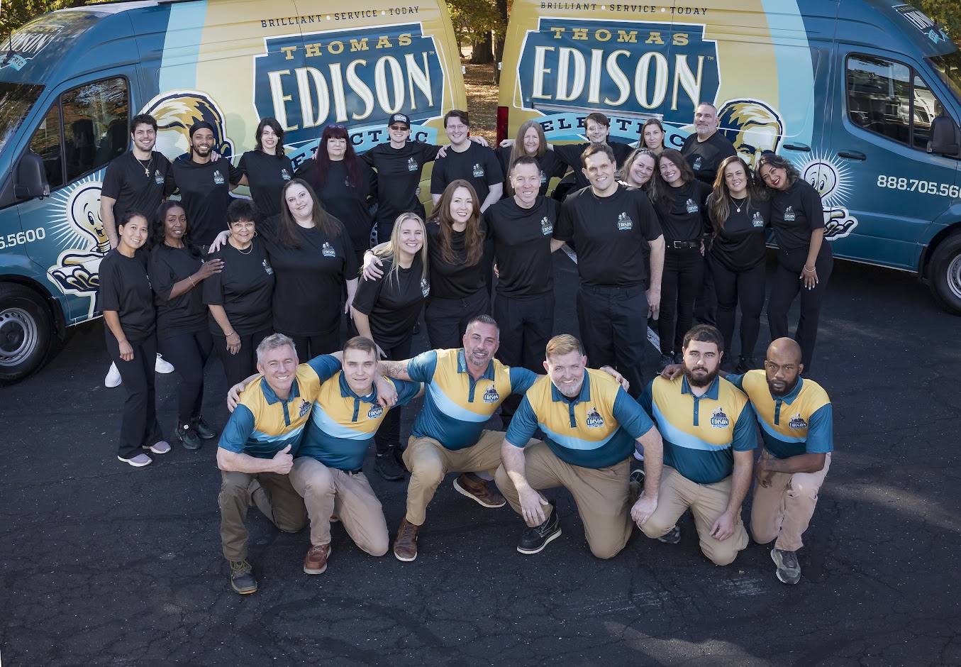 Full team photo of Thomas Edison Electric electricians and staff gathered in front of company service vans, representing residential and commercial electrical services across Montgomery County and surrounding Pennsylvania areas