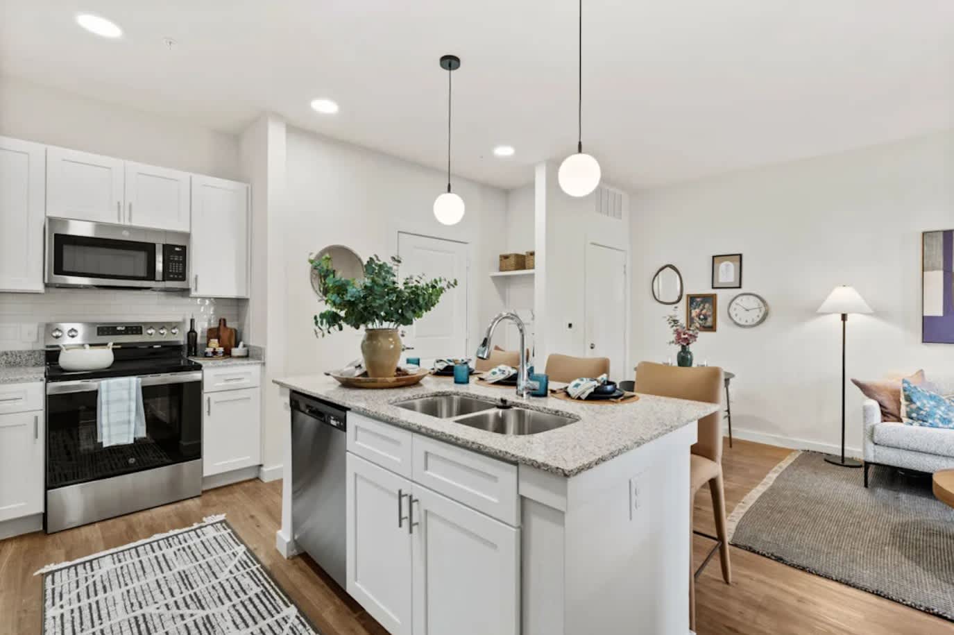 A modern kitchen with white cabinets and stainless steel appliances 