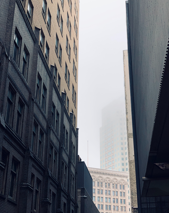 View up a narrow alley between tall buildings.