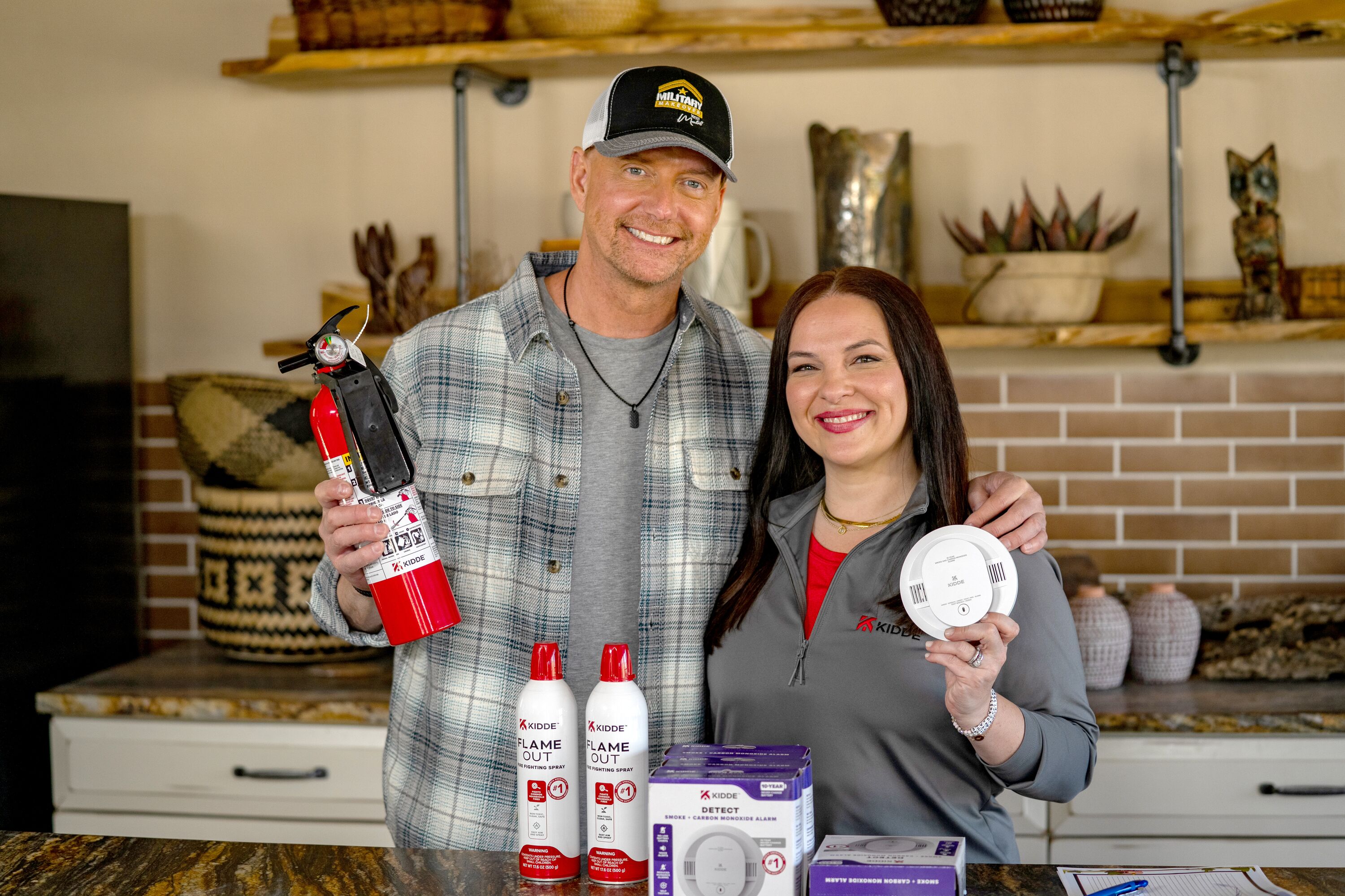 Kidde's Stephanie Berzinski and Art Edmonds from Military Makeover posing holding Kidde fire safety products.