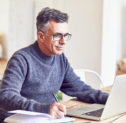 Professional man on his laptop and taking notes.