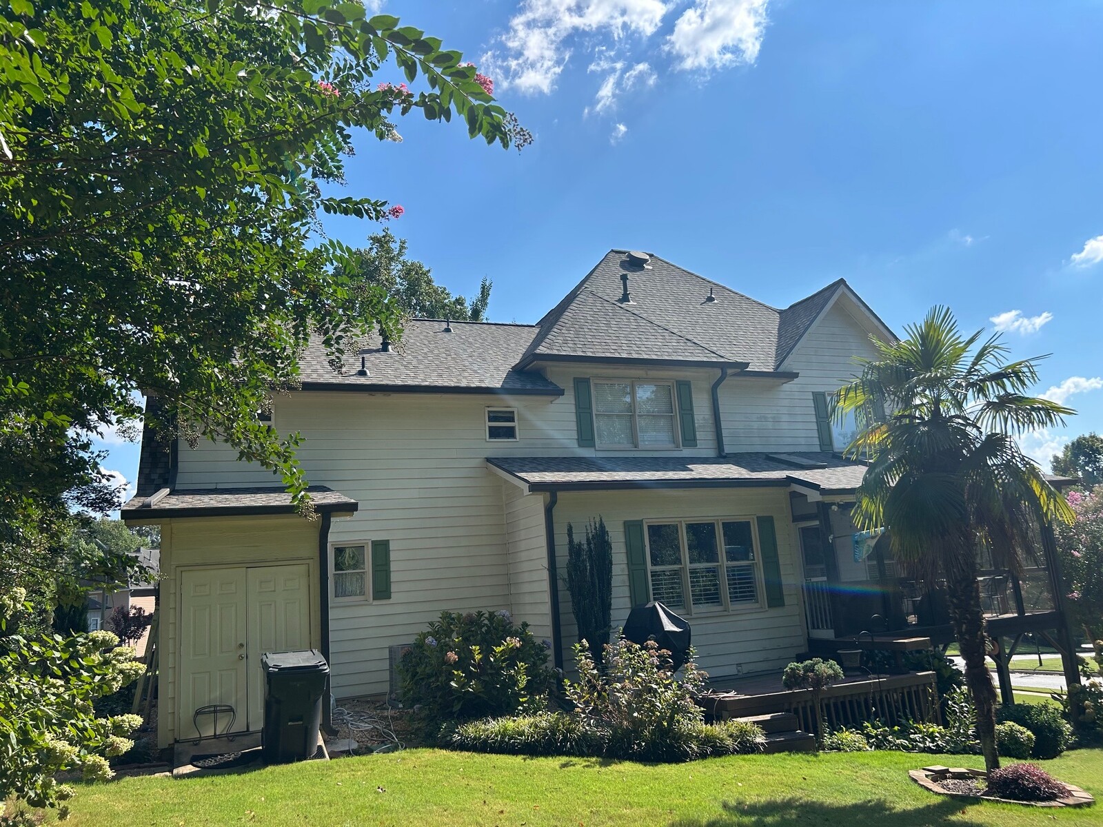 Completed architectural asphalt shingle roof on a two-story light-sided residence.