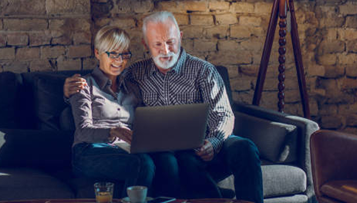 A couple on their laptop at home.