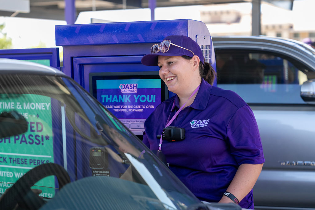 Friendly DASH Car Wash team member assisting a customer at the pay station. 